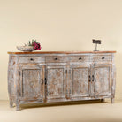 Side view of a hand carved Mango wood sideboard with floral design, 4 doors and 4 drawers in vintage distressed look.