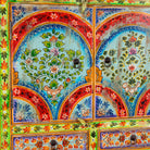 Close up image of a hand-painted cabinet made from reclaimed wood with colourful floral motifs – a sustainable furniture piece ideal for expressive Indian home decor.