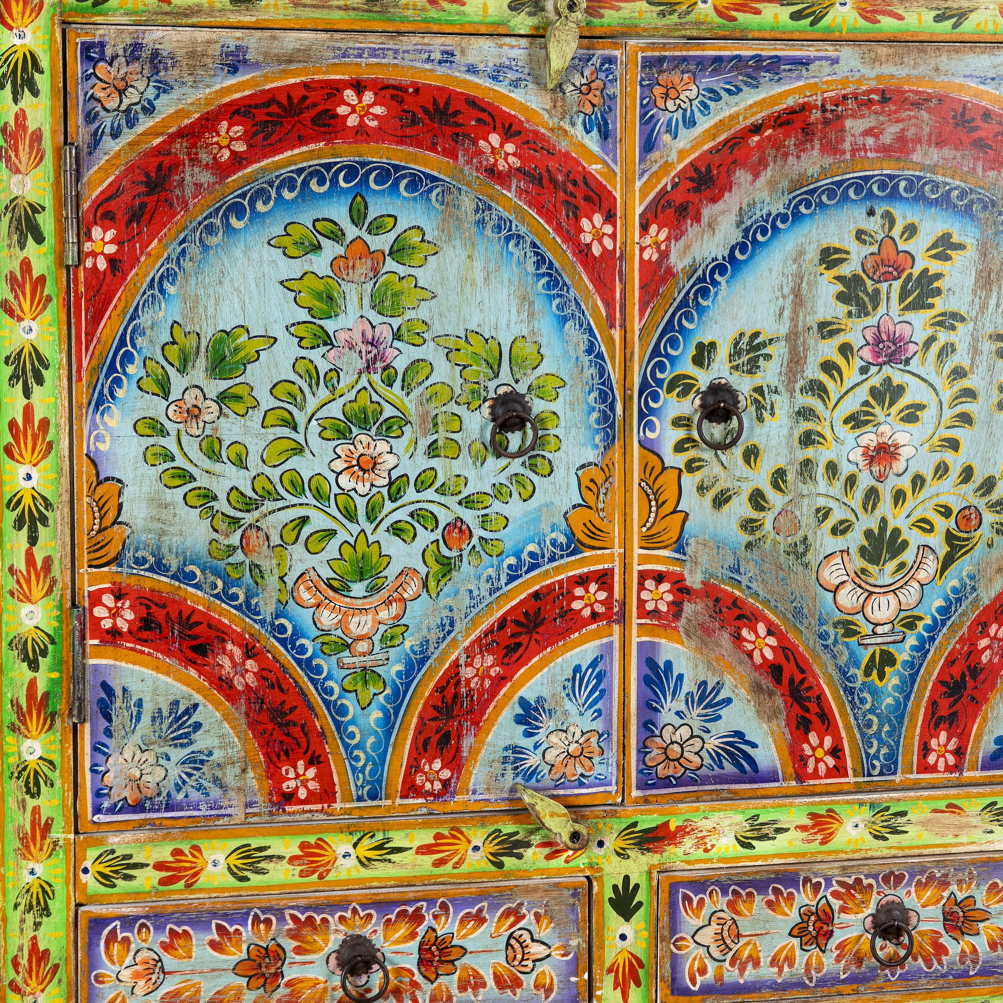Close up image of a hand-painted cabinet made from reclaimed wood with colourful floral motifs – a sustainable furniture piece ideal for expressive Indian home decor.