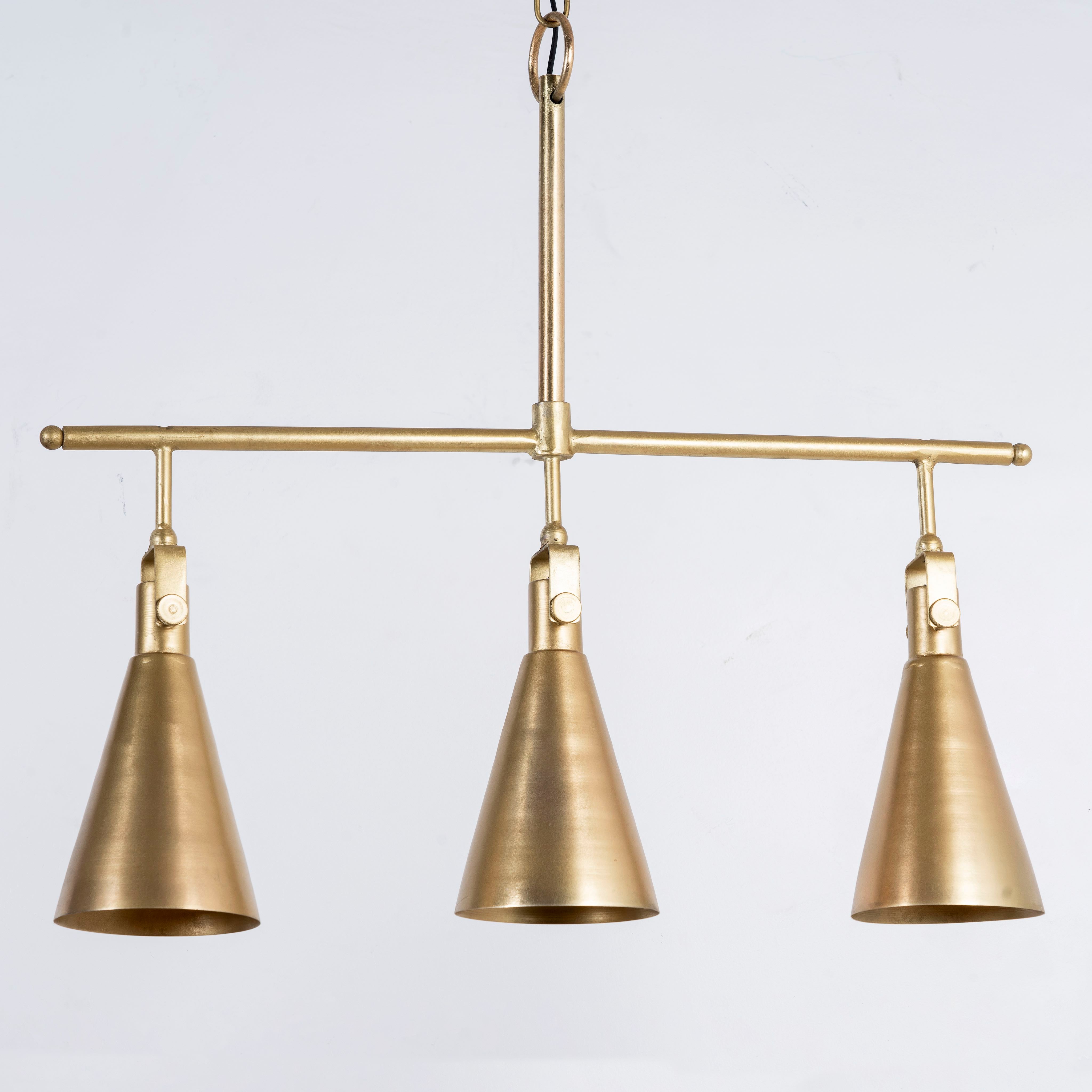Three-light iron pendant lamp with brass finish and tapered design – minimalistic style lighting and iron pendant lights for modern interiors.