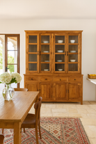 Lifestyle image of a two-part reclaimed teak wood cabinet with glass upper display and solid lower storage – timeless teak wood furniture for elegant dining room interiors.