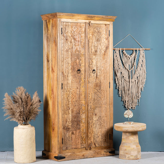 Side angle image of a hand-carved mango wood cabinet with traditional Indian village scenes – Rewalsar by Om Home & Garden, carved wooden furniture with cultural depth for bedroom interiors.