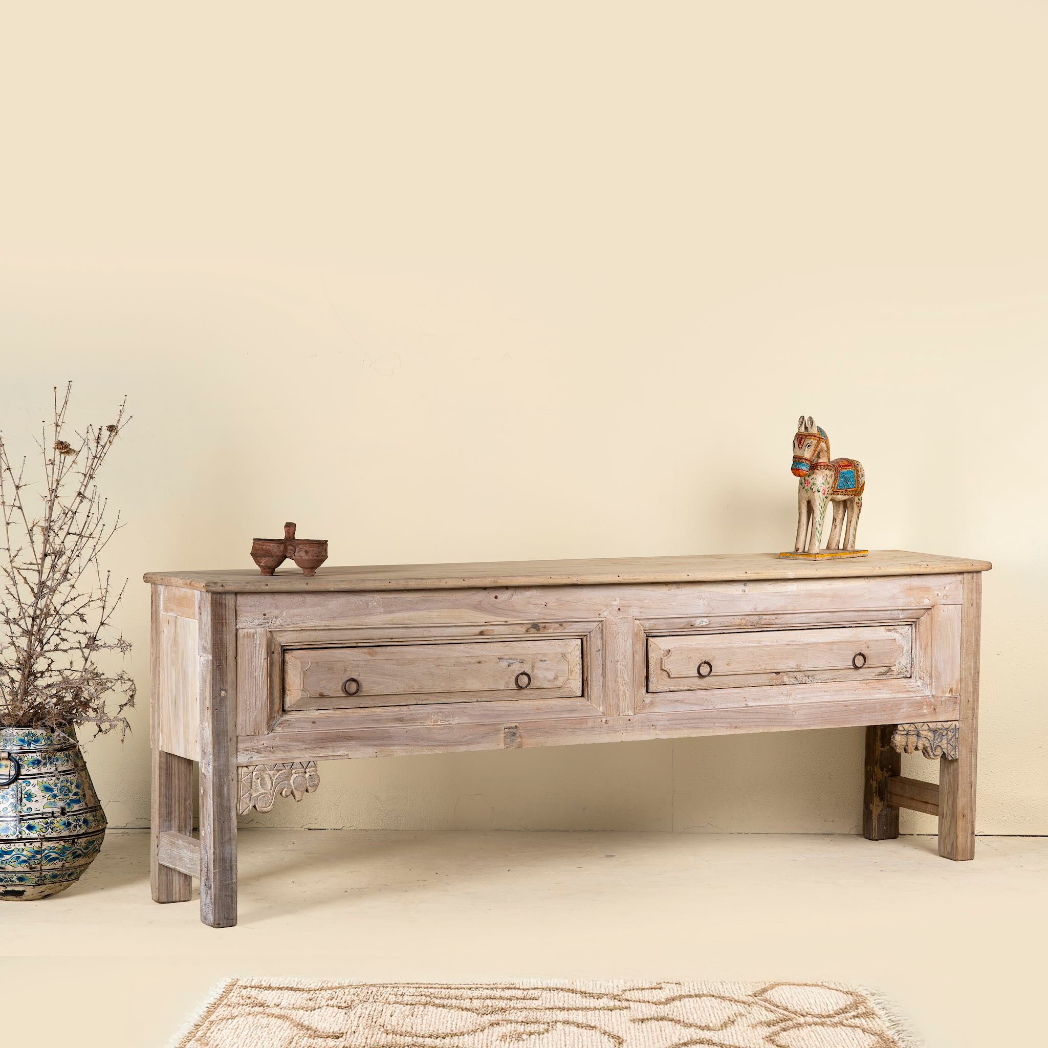 Side angle picture of a carved console table made from reclaimed teak, a refined example of unique wooden furniture.