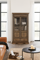 Lifestyle image of a hand-painted display cabinet made from recycled wood with glass doors – sustainable furniture featuring Sanskrit motifs and traditional Indian craftsmanship.