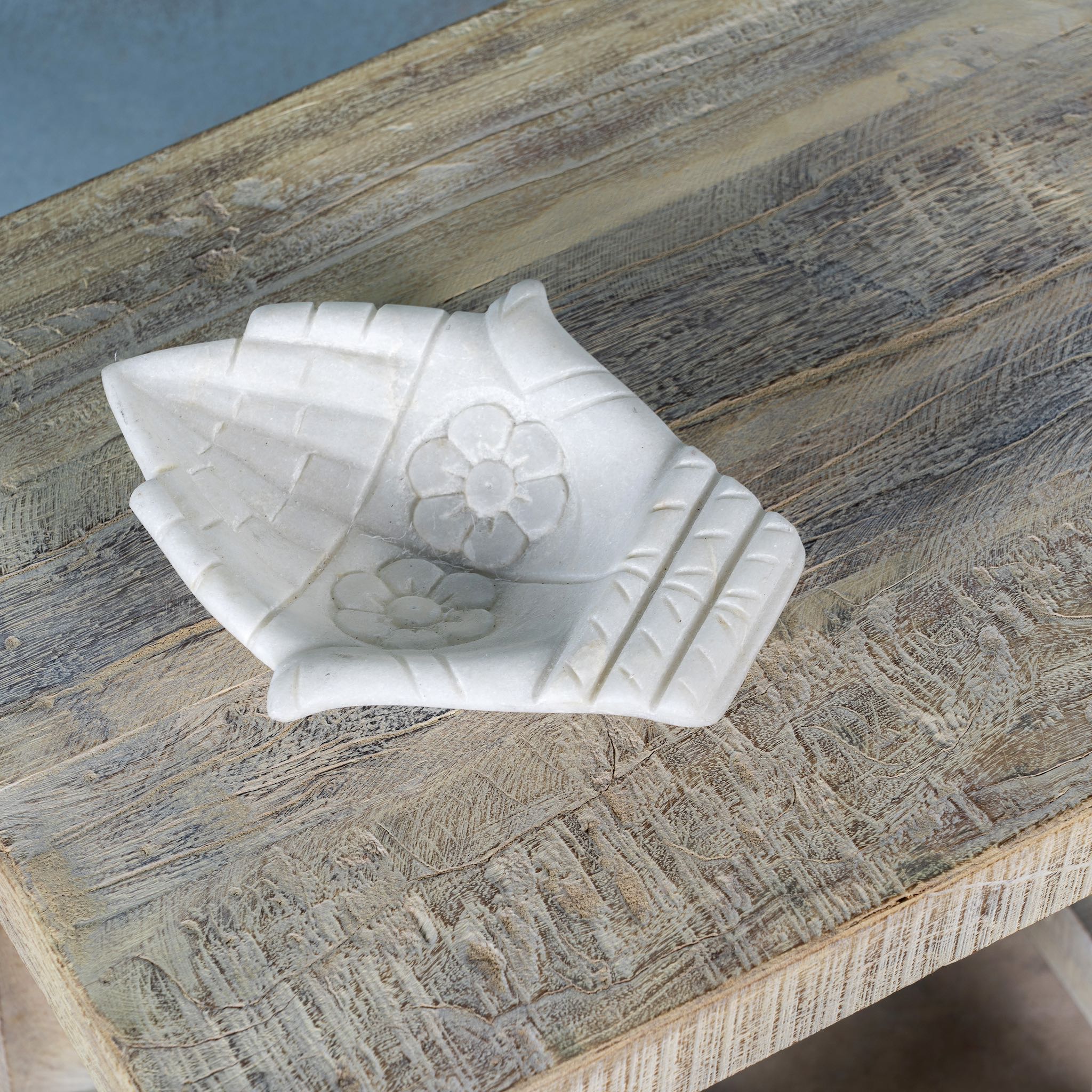 Close up image of a small driftwood bench made of reclaimed wood with sandblasted finish; sustainable furniture, rustic design, 40 × 35 × 50 cm.