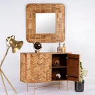 Side angle image with open door of a handmade teak wood cabinet with chevron pattern, brass stand, and handles—minimalistic style living room furniture with modern and natural appeal.