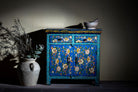 Lifestyle image of a hand-painted cupboard made of reclaimed wood with vibrant floral design – Tvesa model by Om Home & Garden