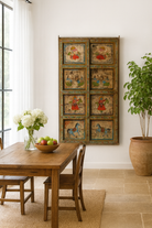 Lifestyle image of a Vedant hand-painted teak wood wall decoration featuring eight illustrated folklore panels, an expressive and detailed wall decoration from antique Indian door panels.