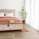 Lifestyle imagination of a long mango wood vintage display box and wood chest box with hand‑carved circular motifs, iron fittings and whitewashed finish; 180 × 55 × 46 cm.