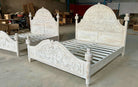Carved wooden beds with intricate designs in a warehouse setting