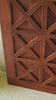 Sliding door panel crafted from reclaimed wood, featuring a bold geometric grid design with layered X-pattern carvings for a modern rustic look.