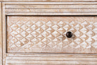 Close up image of a hand-carved console table in mango wood with whitewashed finish, perfect for a bohemian interior.