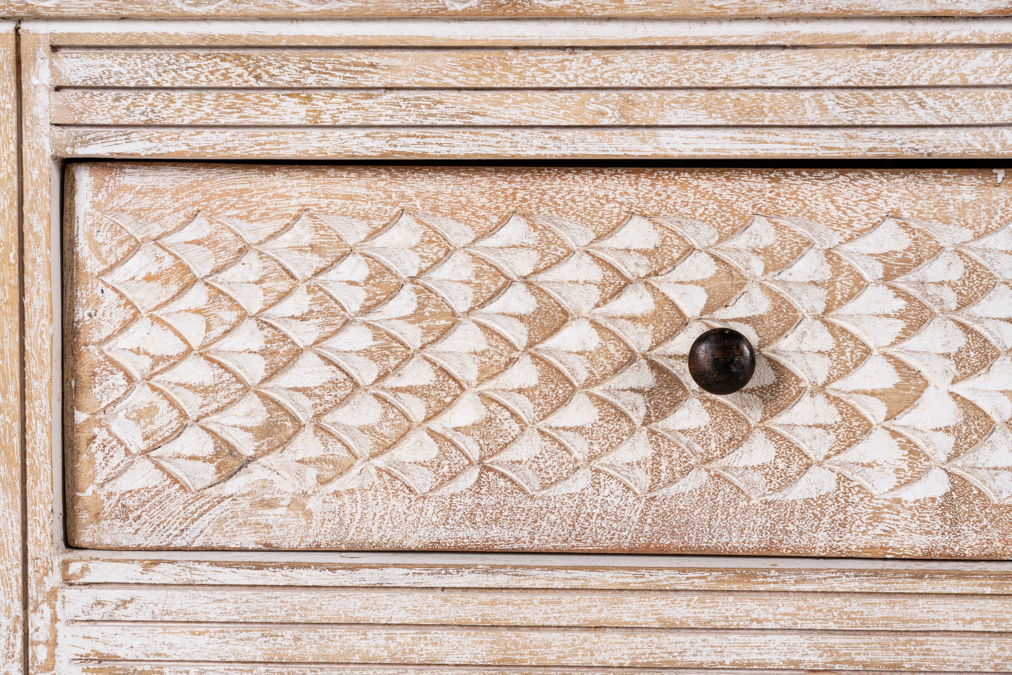 Close up image of a hand-carved console table in mango wood with whitewashed finish, perfect for a bohemian interior.
