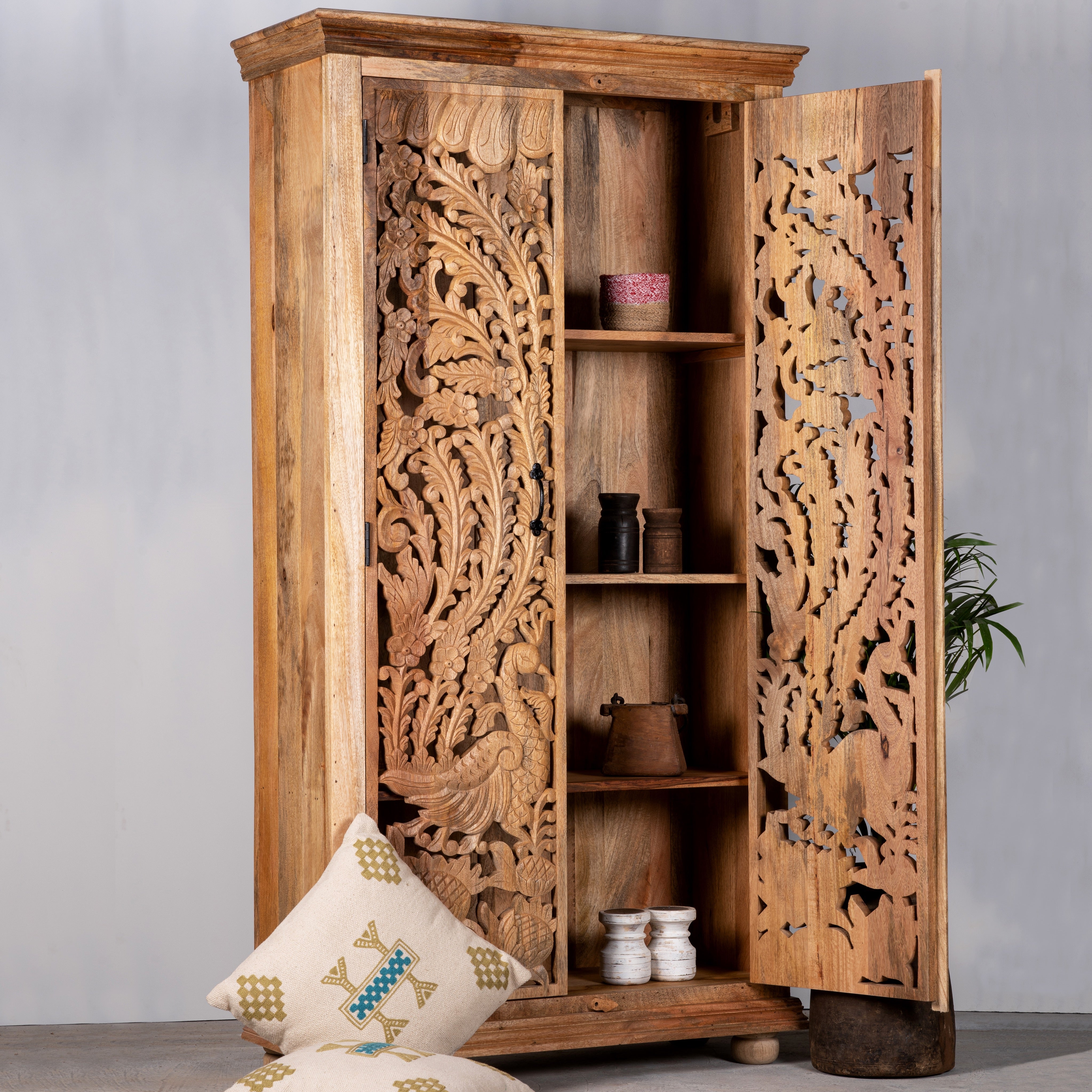 Open door image of a hand-carved mango wood cupboard with Indian peacock design motifs, Mediterranean-style wardrobe; elegant mango wood furniture, 190 × 100 × 40 cm.