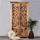 Lifestyle image of a hand-carved mango wood cupboard with Indian peacock design motifs, Mediterranean-style wardrobe; elegant mango wood furniture, 190 × 100 × 40 cm.