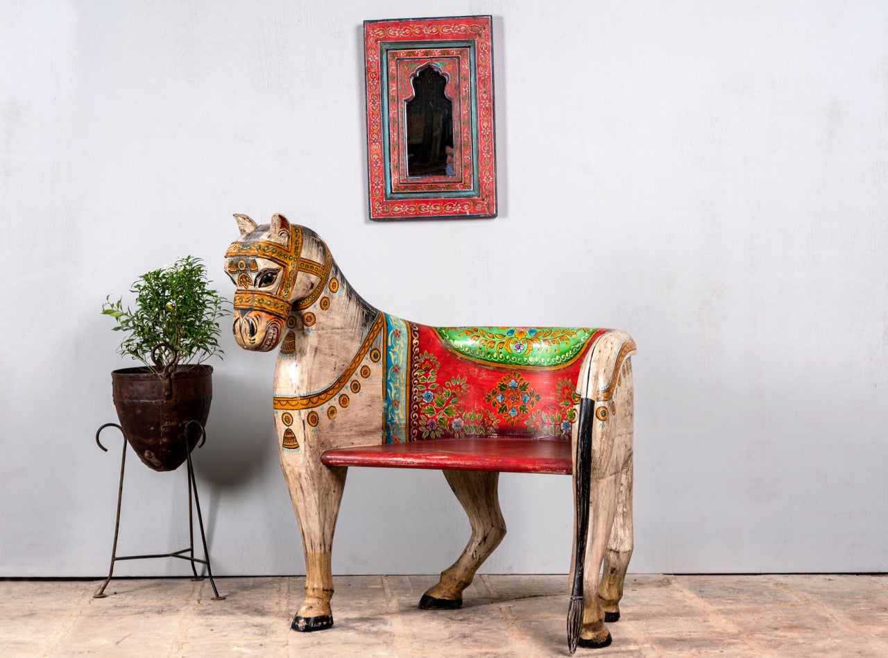 Side angle image of a hand‑painted Horse Chair made from recycled teak wood with carved horse design and vibrant Indian folk art detailing, showcasing artistic and sustainable Indian furniture.