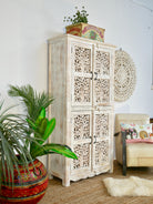 Side angle image of a hand-carved mango wood cabinet with white-washed finish – artisanal furniture combining Mediterranean design and functional elegance.