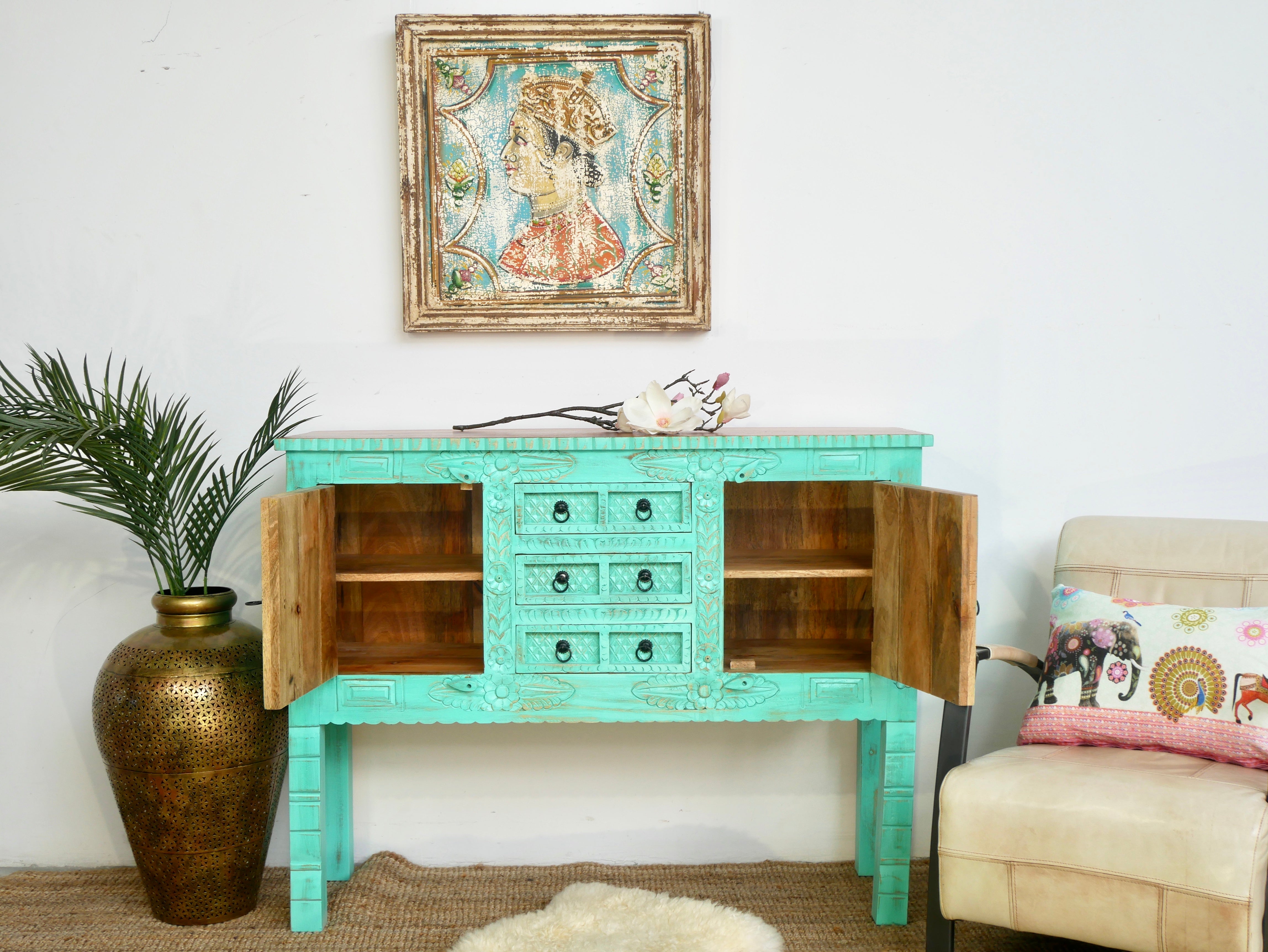 Open door image of a green storage console table with carved mango wood doors and brass details; mango wood console table, 130 × 100 × 40 cm.