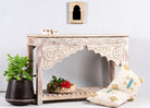 Side angle image of a Kolkata carved wood console table in solid mango wood, vintage entryway table with floral motifs and storage shelf, 130 × 84 × 44 cm.