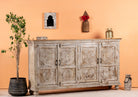 Side angle image of a handcrafted carved sideboard made from reclaimed wood with floral motifs and distressed finish; suitable as bedroom furniture, 180 × 40 × 100 cm.