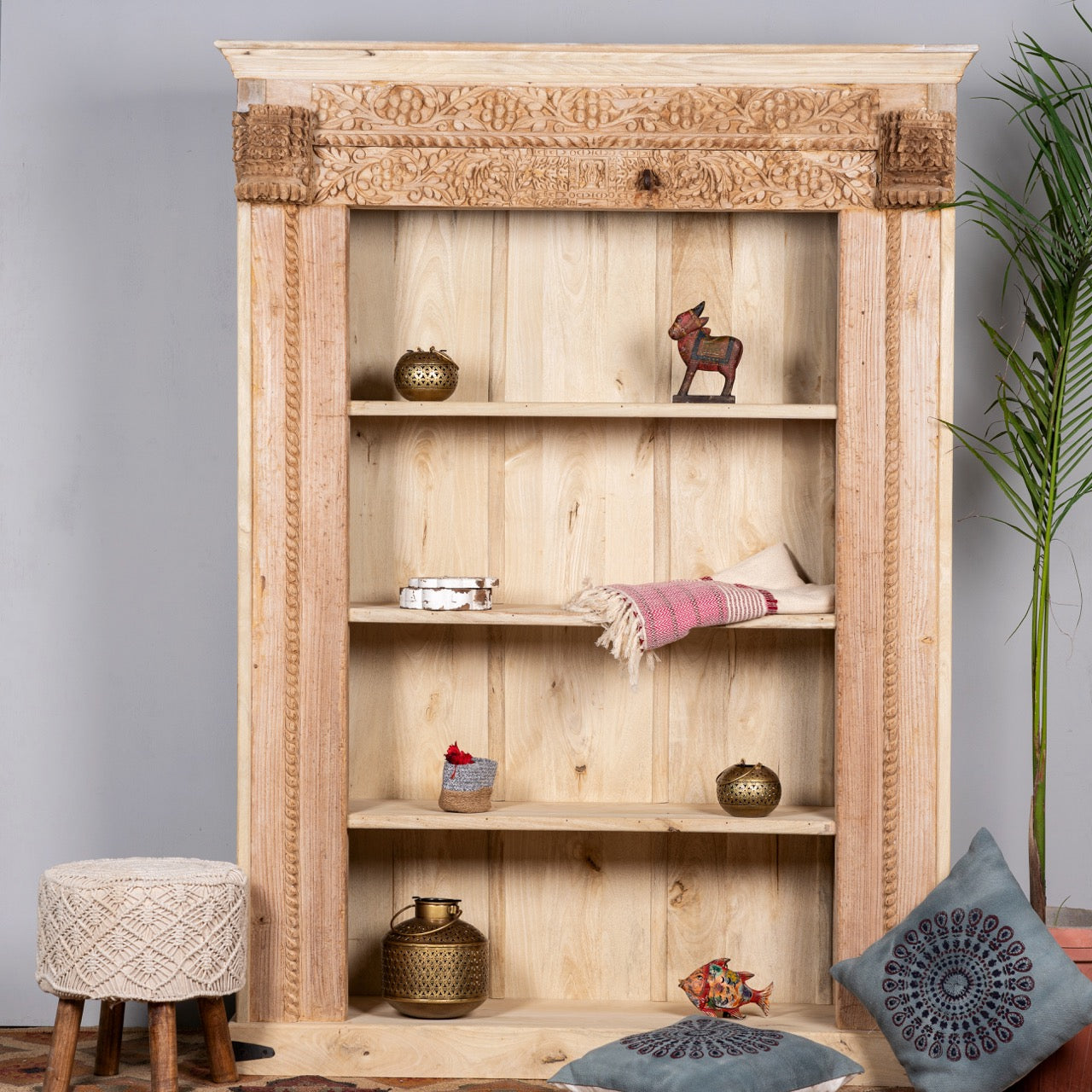 Lifestyle image of a hand-carved shelf made from reclaimed teak wood and mango wood, unique furniture with Ibiza-inspired finish, 152 × 206 × 51 cm.