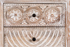 Close up image of a hand-carved mango wood sideboard with lotus-inspired drawer motifs and whitewashed finish; a wood carved sideboard and unique furniture piece, 160 × 92 × 45 cm.