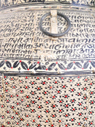 Close up image of a hand-painted iron floor vase with Sanskrit motifs – a one-of-a-kind painted iron decoration perfect for bohemian interior styling.