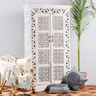 Side angle image of a hand-carved mango wood cabinet with floral and geometric patterns in white-wash finish – carved wooden furniture and artisanal furniture with Mediterranean charm.