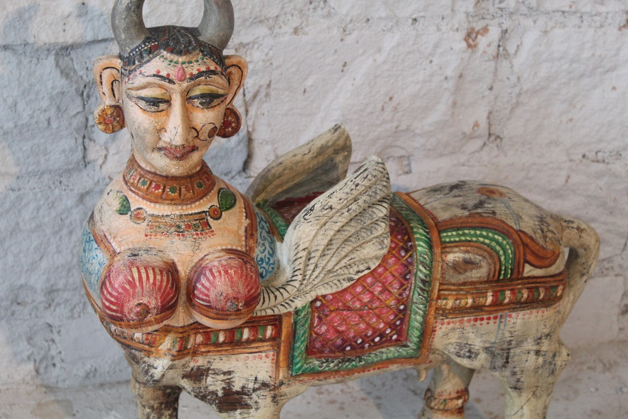 Close up image of a hand-carved Kamadhenu Indian wooden sculpture made from recycled teak – artistic Indian home accessory with painted detail, 70x40x20cm.